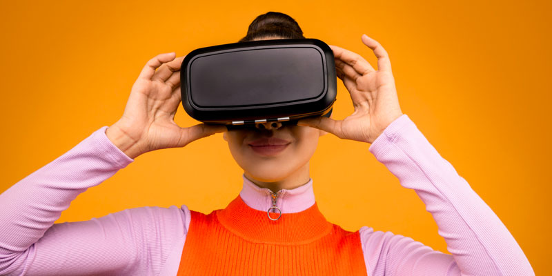 Une femme portant un casque de réalité virtuelle et nous faisant face