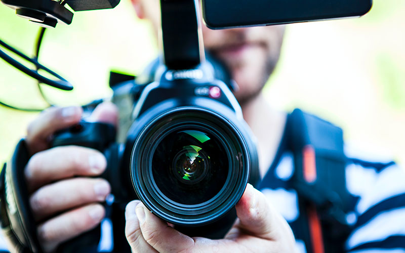 Un caméraman tourne sa caméra vers nous, pour tourner une vidéo pédagogique